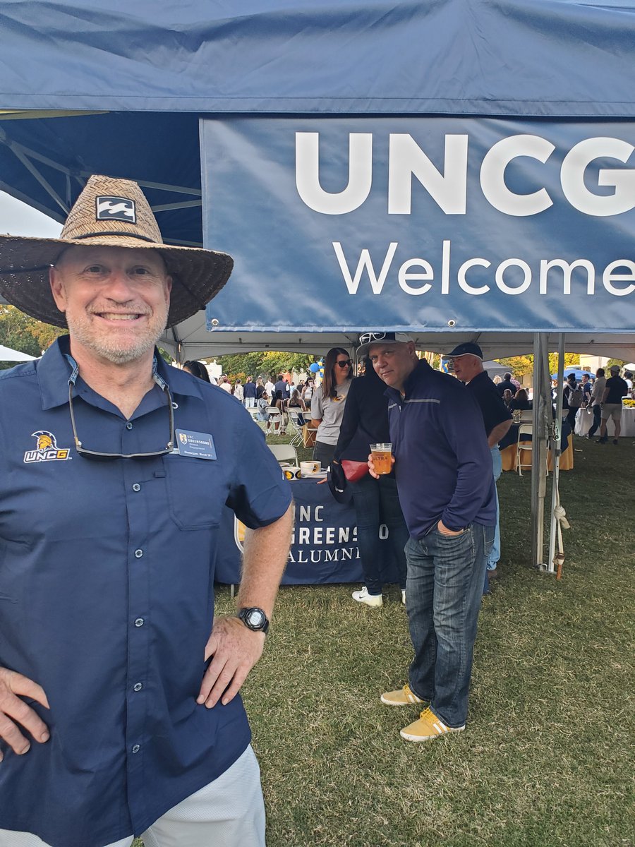 Call him Mr. Homecoming  -- Donegan Root '87 of UNCG Alumni Engagement makes the magic happen year after year. Brian Japp '87, background, of Latitude 36 in Greensboro, gets an assist for supplying mountains of Spartan swag. #uncghome #uncgalumni