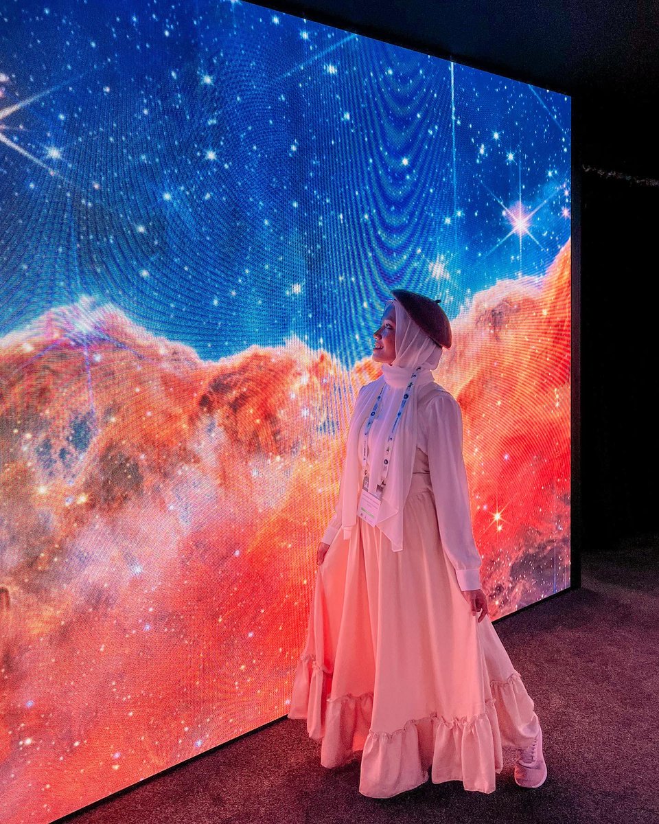 AstroSyahirah's tweet photo. Marvelling the universe through JWST’s lense at the @NASAExhibit during the IAC Paris 2022. I can’t help but to drown in the cosmic wonders into this immersive display of nebulas, stars and planets❤️ 
#jwst #nasa #iac2022 #nasabooth #spaceart https://t.co/WjAIkrcRkw