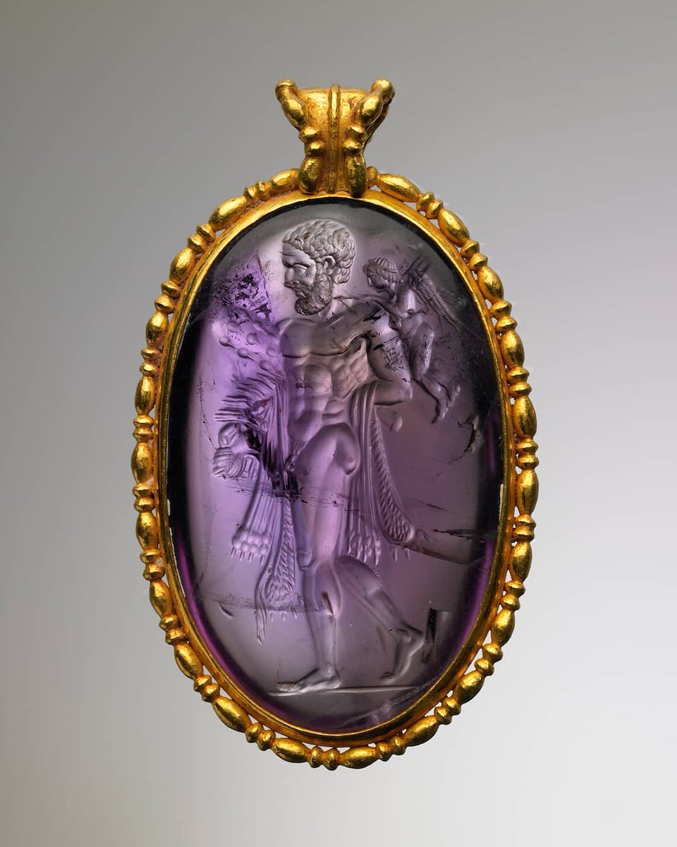 Ancient Greek amethyst intaglio, set in a modern gold pendant. It depicts Eros binding the arms of Herakles. Date: 2nd century BC. Private Collection
