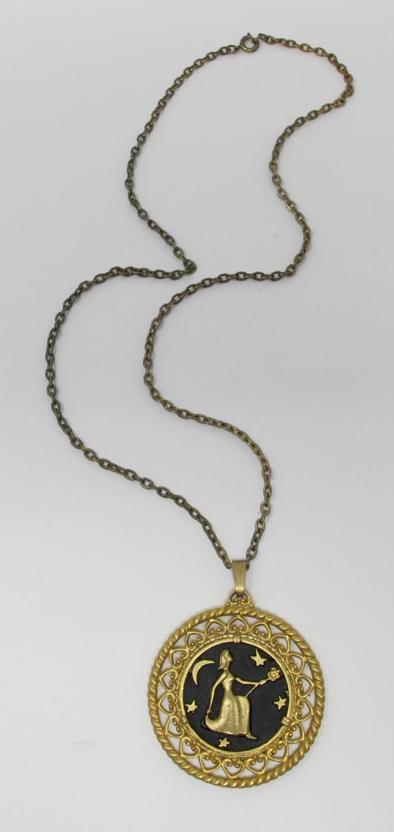 docbrite's tweet photo. Dating from the 1960s, this talismanic necklace features a gold filigree pendant with an image of a woman, evidently a witch or sorceress, making a flower offering beneath the light of a crescent moon and stars. I've never seen a piece like it.

https://t.co/JzJFRNPH2k https://t.co/T1nnsuqAJS