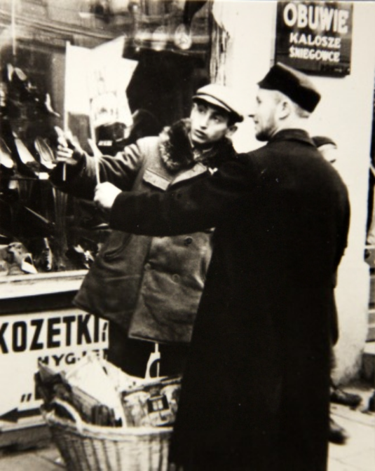 yivoinstitute's tweet photo. A man selling flags for Simhat Torah, in front of a shoe store, for the procession to celebrate the end of a year's cycle. Warszawa, 1930s. 

#fromtheyivoarchives #simchat torah #simhattorah #simkhestoyre https://t.co/cLx3bT7X03
