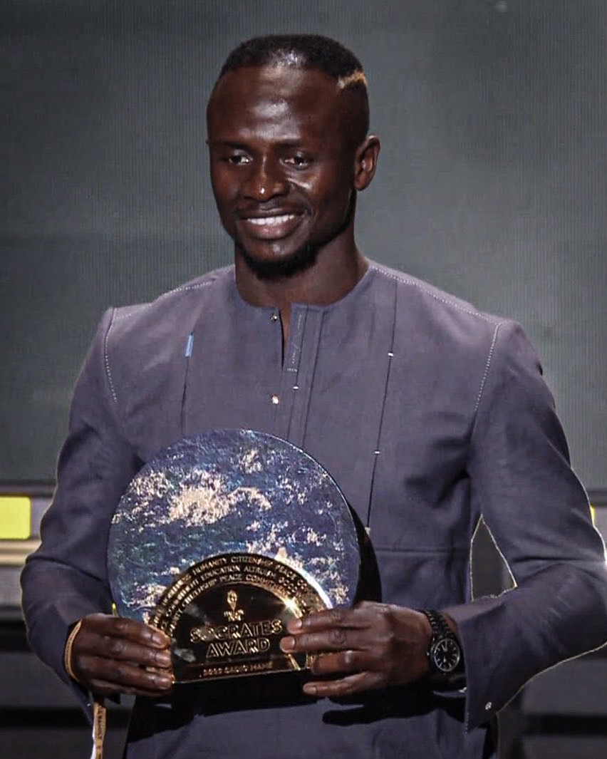 RemarksFootball's tweet photo. Sadio Mané wins the new Sócrates Award for social involvement in football.

▶ Built a school worth €270,000. 
▶ Built a hospital worth €530,000
▶ Gives each family €70 monthly
▶ Access to the 4G network thanks to his partnership with Orange. 

A man with a golden heart! ❤️ https://t.co/OmzBBq9Ggg