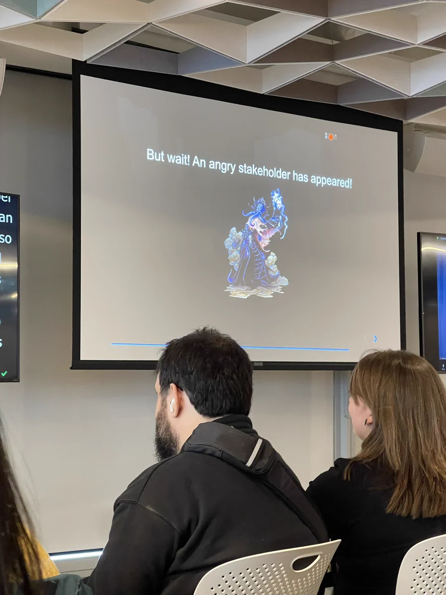 A screen with a slide with a dark background and an illustrated character of a mind flayer with the text but wait! An angry stakeholder has appeared!