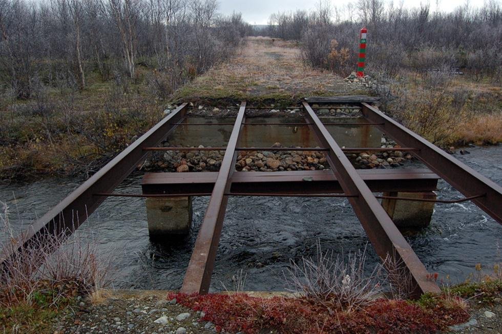 Pillandia's tweet photo. Abandoned bridge on the border between Norway (foreground 🟨⬛️) and Russia (background 🟥🟩). 
It was part of a WWII German supply road towards the Murmansk front. 
Location: 69°33'34.0"N 30°55'54.0"E. 
https://t.co/11FWMYznv0 

#Norge #Norway #Grense #Grenze #WWII #Border https://t.co/sgYFqI5imx