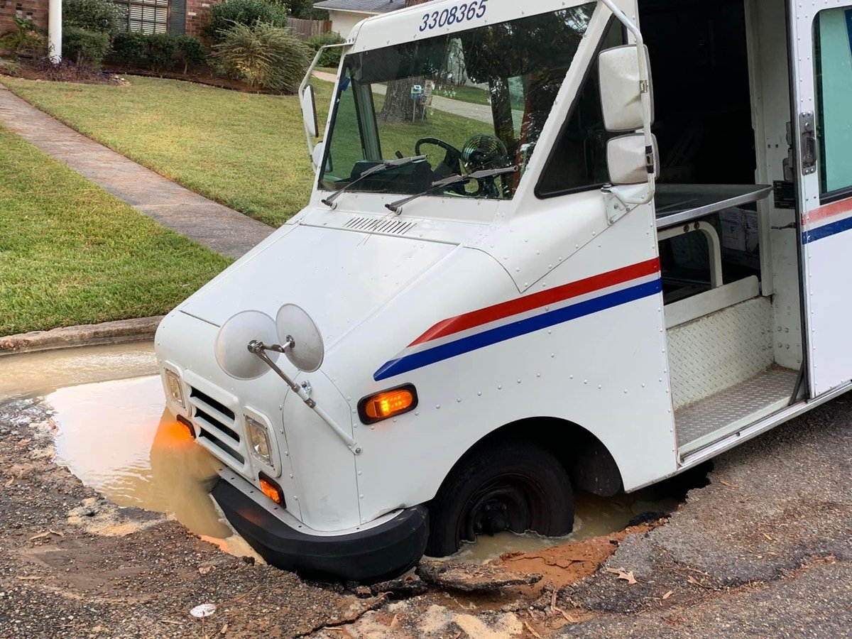 WLBT's tweet photo. A postal worker parked on Woodlark Street in NE Jackson Monday afternoon, according to a resident. Moments later, the ground gave way beneath him, after water had been running about 48  hours. Neighbors have now set up a makeshift roadblock to protect drivers. https://t.co/YVg4JNkZ19