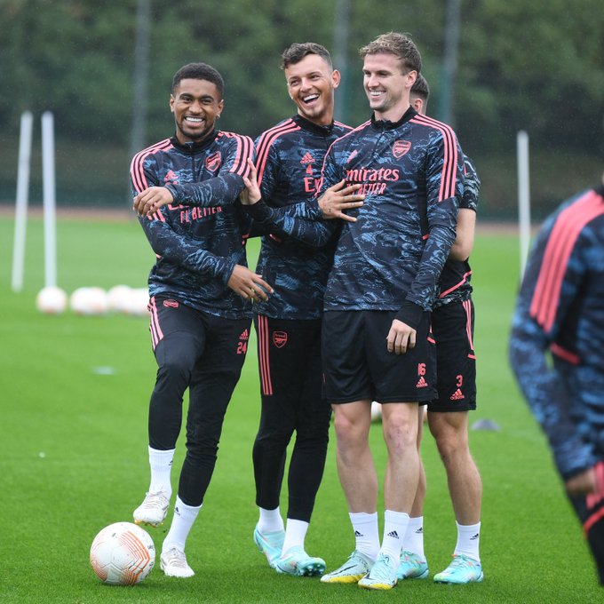 Reiss Nelson, Ben White and Rob Holding laughing together at today's rainy training session