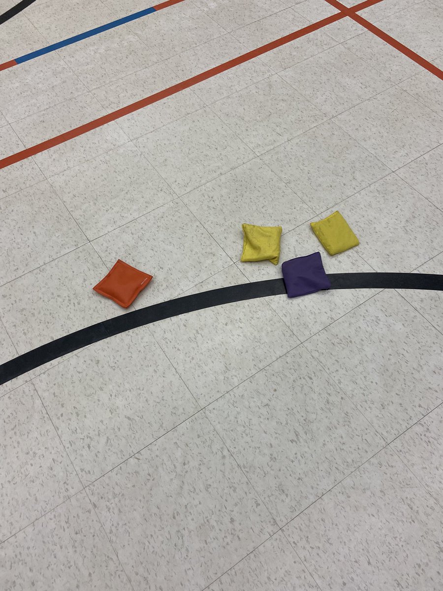 CorcoranMarlee's tweet photo. Who scores the points? How many points do they score? Our @johnmccraeps Ss are answering these Qs in their #beanbagbocce games in #physed while working on the #sendingskill of underhand throwing! We’re doing a little #math too when we need some #measurement help to decide! https://t.co/qcNlL07n19