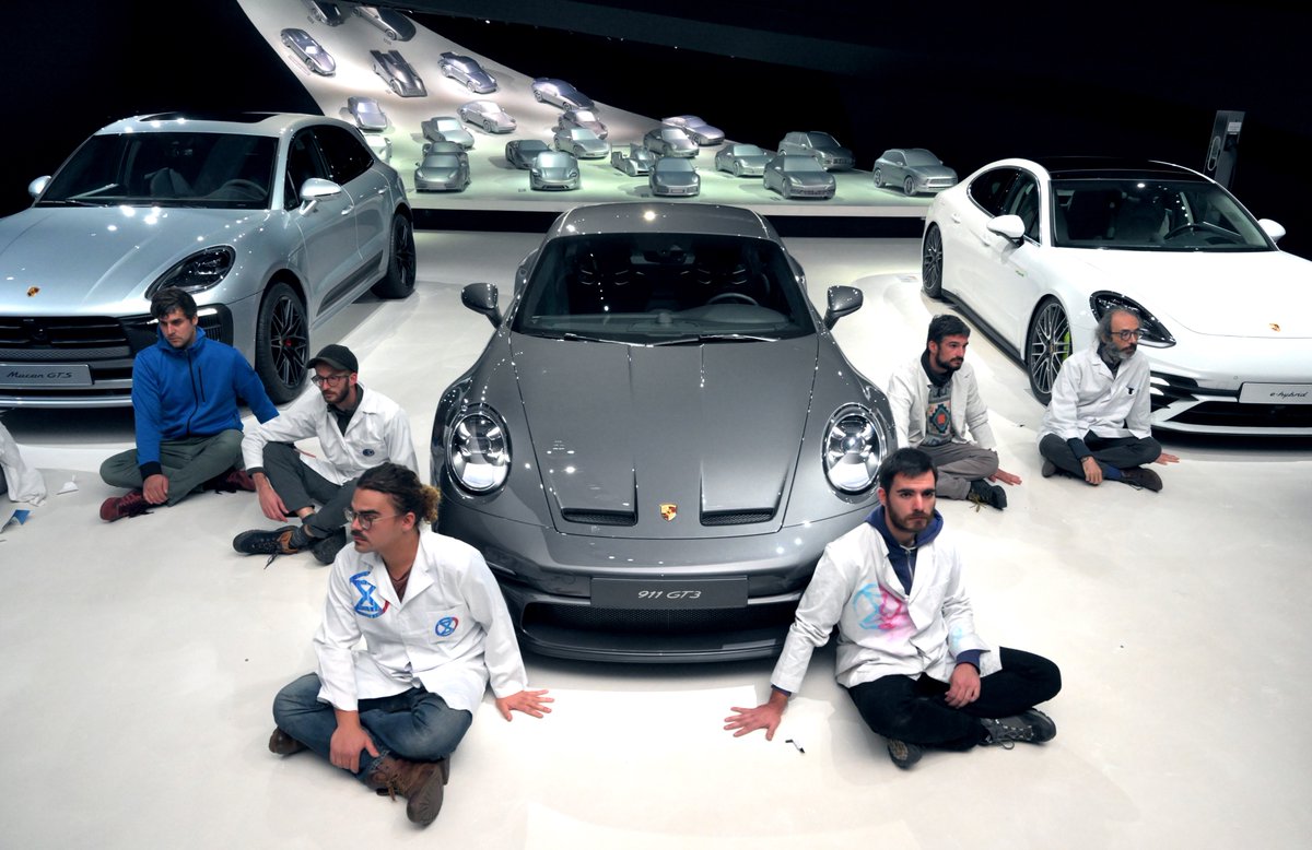 ScientistRebel1's tweet photo. 9 members of #ScientistRebellion remain glued at @Porsche pavilion in @autostadt. Usually @volkswagen lobbies politicians in Berlin &amp; Brussels. Instead, we ask CEO #OliverBlume to lobby for the climate by pushing @OlafScholz &amp; @Wissing to install a speed limit of 100 km/h. https://t.co/tWBrrpcoUr