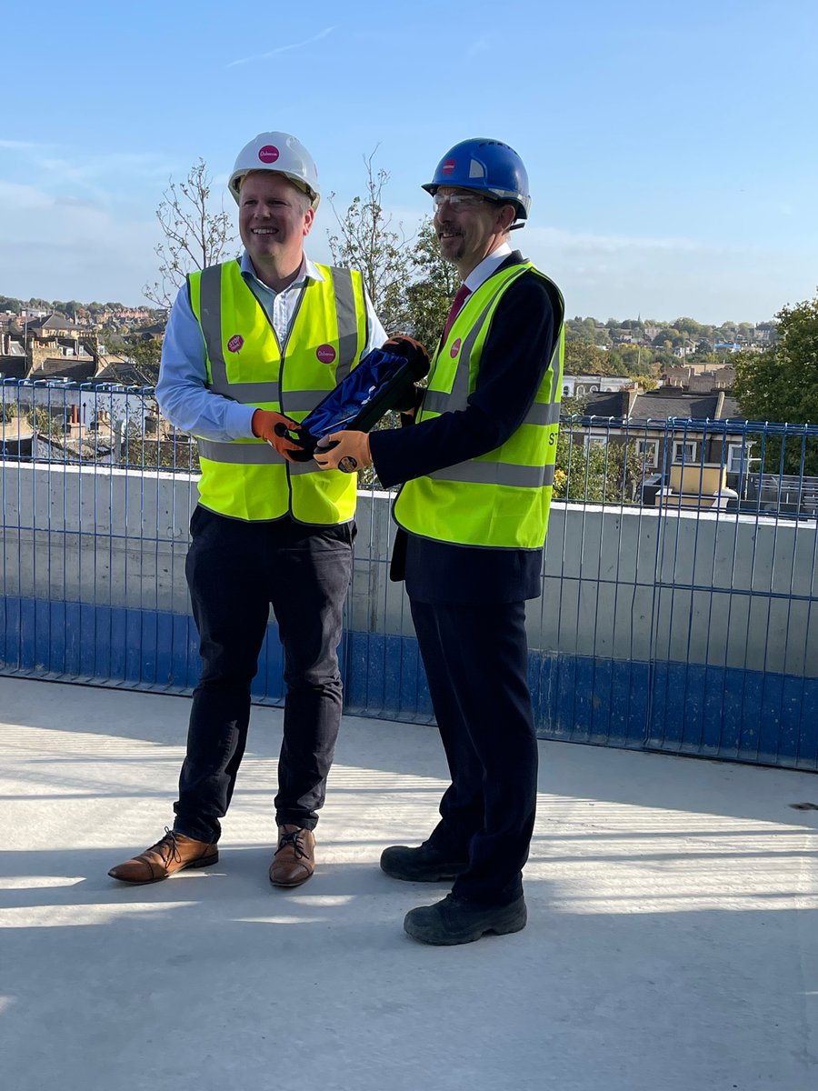 OsborneNews's tweet photo. Cllr Diarmuid Ward @IslingtonBC receiving the ceremonial  #ToppingOut trowel from Chairman Andrew Osborne, above the Andover Estate project in Finsbury Park. Congratulations to all! #IslingtonCommunity #FinsburyParkHomes #HousingPartnerships #HighestPointInTheBuild https://t.co/0DaHQrnOr5