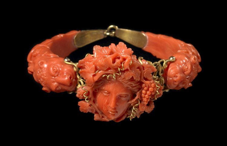 Bracelet. Carved-coral vine-wreathed head of Bacchus with gold mounts and panther-headed terminals, in a labelled case. Made by: Kirkby & Bunn, 1800's.Made in: Naples, Italy. Materials: coral and gold Collection: British Museum, UK.