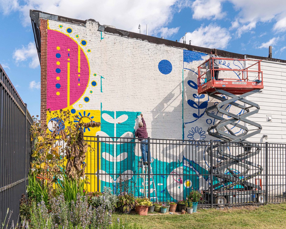 Awesome mural rising above the Locust Point Community Garden today on Haubert St. Design by Nicole Buchholz (on the lift). @BaltFamilies @BaltimoreMD @UnderArmour #locustpoint #Baltimore