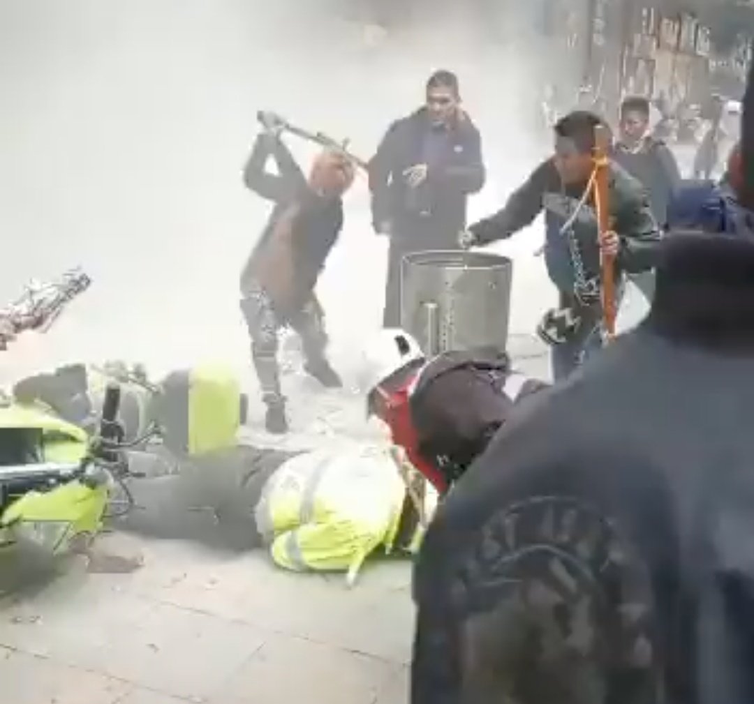FisicoImpuro's tweet photo. Así como condenamos la violencia hacia los manifestantes, tmbn condenamos en cómo acabaron a palos al policía en el suelo. Ambas cosas están mal. Ese es el legado de sangre y violencia que nos dejó Iván Duque a raíz de su actuar durante el estallido social. Hay rencores por sanar https://t.co/82rC71nf8M