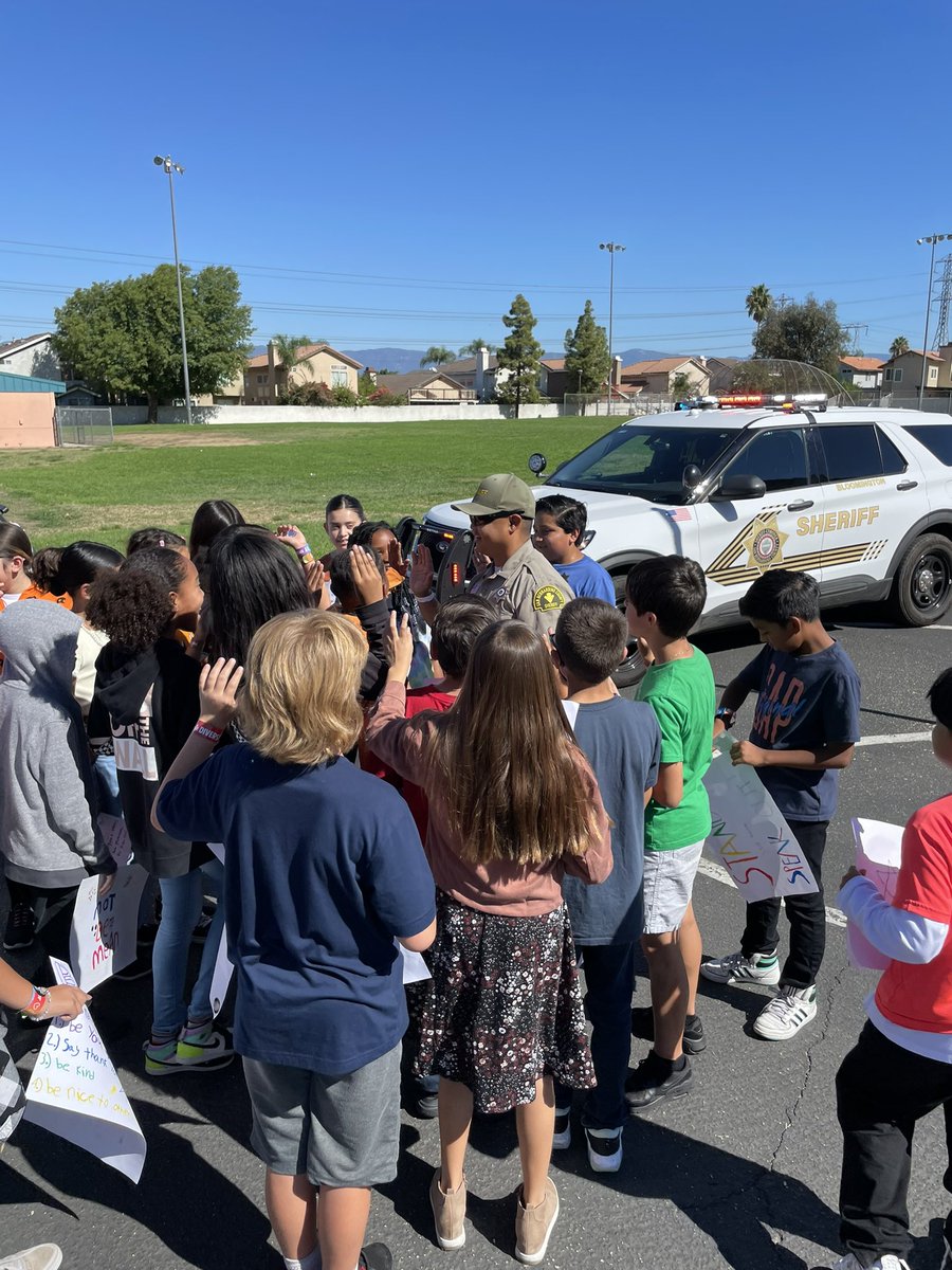 CJUSDSafety's tweet photo. @fontanastation #SRO/Deputy Dominguez brought backup to help spread messages of #kindness @JVRoadrunners. #Students were even sworn in as #JuniorDeputies before taking a group picture at today’s #UnityDay22 celebrations. #KindnessBus #BullyingPrevention #SBCSD #cjusdS3 https://t.co/qVejgAnrPj