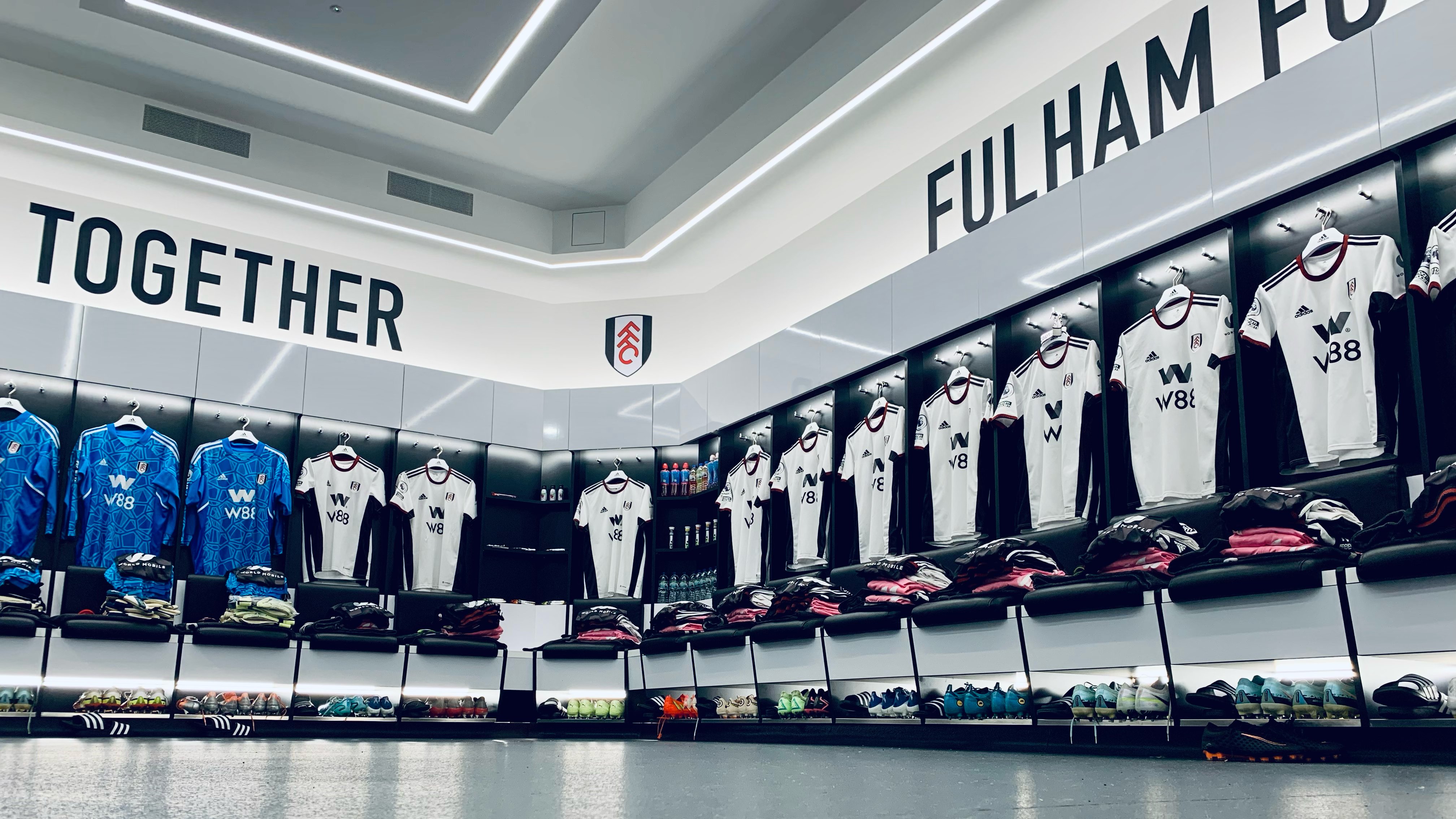 The Fulham changing room pre-match, with 'Together' branding above the hanging shirts.