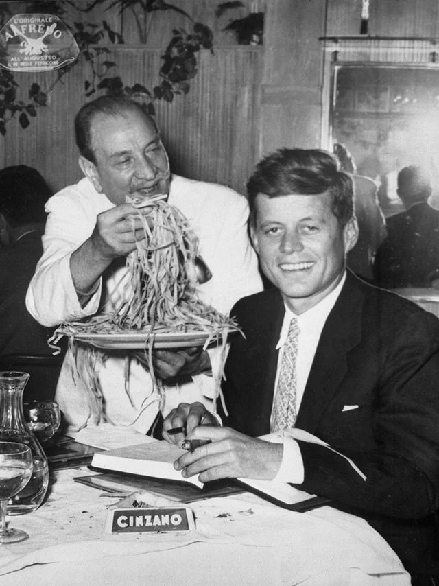 JFK being served fettuccine Alfredo by its inventor, Alfredo di Lelio at the restaurant Alfredo in Rome, Italy. 1963.