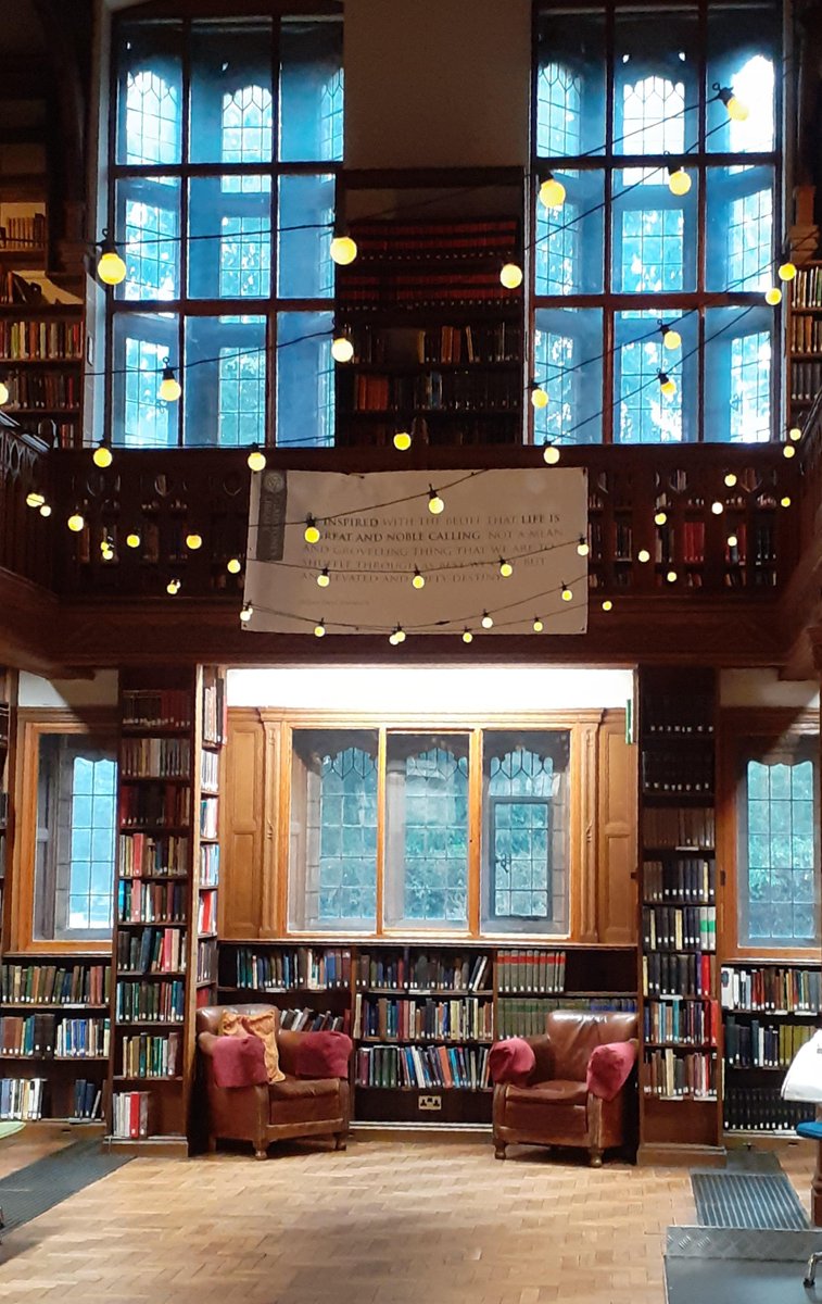 Theology Room ground floor: two levels of windows surrounded by bookshelves. Fairylights are suspended from the gallery