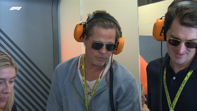 Hollywood legend Brad Pitt watches preparations in the McLaren garage during first practice. He is wearing bright orange earphones and aviator-style sunglasses.