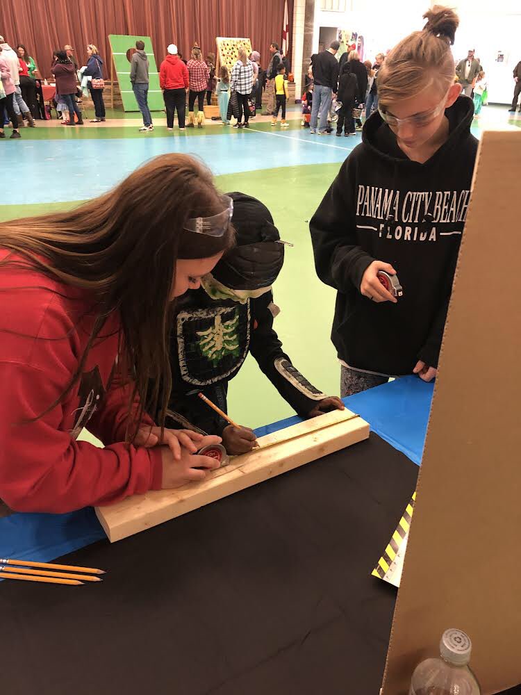 Munford Middle FBLA Ss teaching little ones how to use a tape measure  at <a href="/MunfordElem/">Munford Elementary</a> STEAM Night/Trunk or Treat <a href="/tcboecareertech/">@tcboecareertech</a> <a href="/FlightWorksAL/">Flight Works Alabama</a> #STEMing2Careers