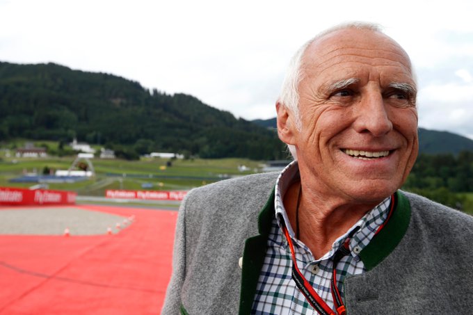 A photo of Red Bull founder Dietrich Mateschitz, smiling off to the right of screen, at the Red Bull Ring in Austria. 