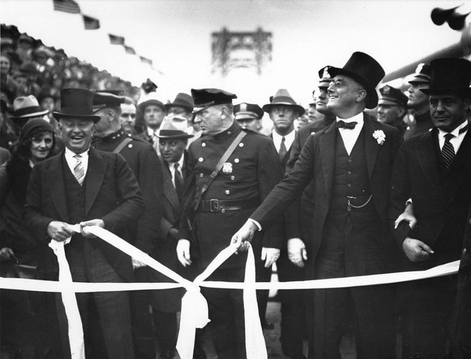 On this date October 24 in 1931: The George Washington Bridge is formally dedicated by Governor Morgan F. Larson of New Jersey, left, and Governor Franklin D. Roosevelt of New York, right, as they cut the ribbon stretched across the bridge in New York City. Photo: AP. #OTD