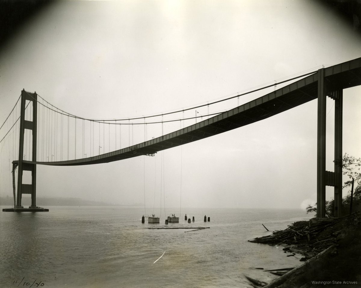 WAStateArchives's tweet photo. At 11:00 a.m., the #TacomaNarrowsBridge finally failed β a large part of the bridge floor and girders fell into the Narrows leaving cables and towers still standing. #RIPTubby https://t.co/JZYX0QWGY4