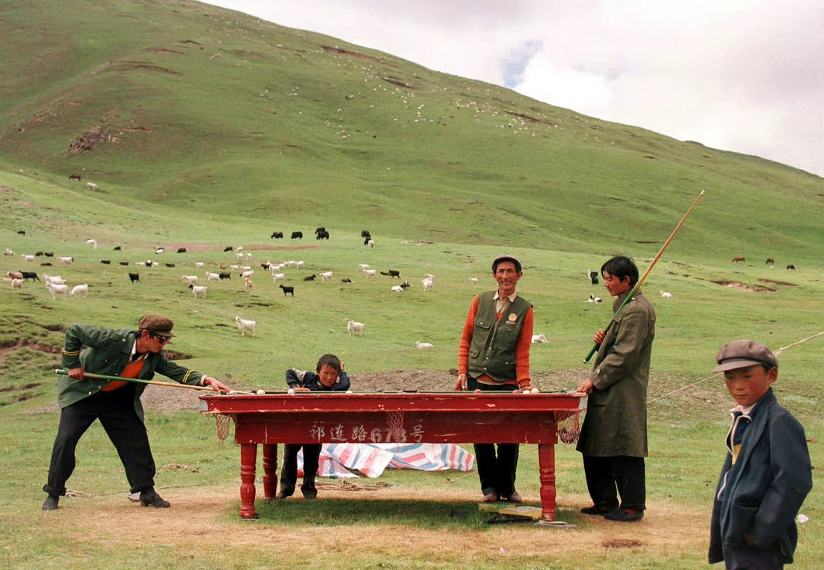 A group of Tibetan herders play billiards on the pasture， near Xiangpi Mountain, China's western Qinghai province，1999.