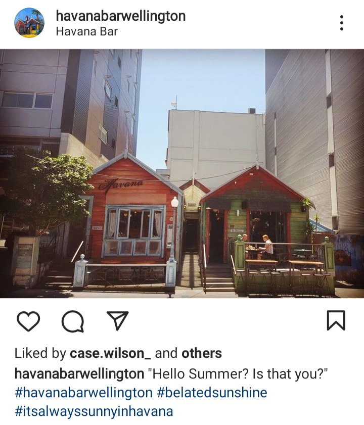 Havana bar IG. Picture of Havana bar in between two large buildings. Captions reads "hello summer? Is that you?" 