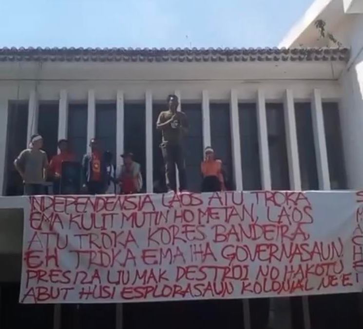 a sign in Tetun hangs from the roof that reads:
“Independence is not to replace white people with black people, not to replace the flag, or replace those in government. It’s about destroying and severing the roots of this colonial exploitation.”