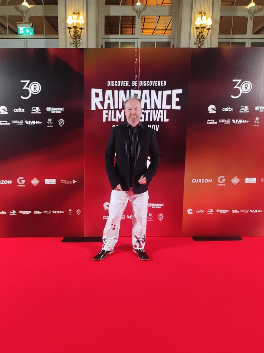 workofstuart's tweet photo. A quiet moment on the red carpet, just before the start of the opening gala of the 30th @Raindance - wearing painted carpenter trousers by LC23 and DJ by All Saints https://t.co/dTzMA5hvzc