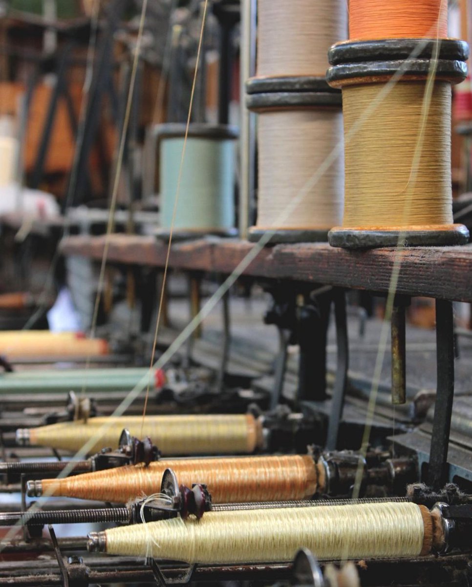 Gainsweaving's tweet photo. An array of cotton yarns being wound together with viscose onto pirns to go into the shuttles on our 1930's Hattersley looms. This creates a lovely flecked weft effect used in a variety of our archive designs.

#Gainsborough #GainsboroughWeaving https://t.co/zYieHLxO48