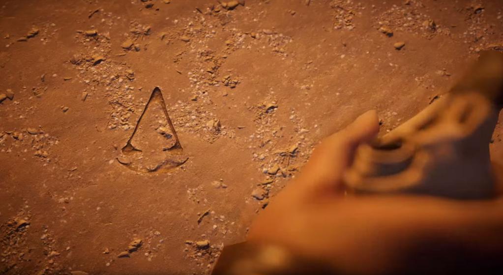 Chiralou's tweet photo. When Aya lifted Bayek's bird skull from the sand, and revealed the symbol of the creed. The goosebumps I felt 💙 https://t.co/woU8w9WV8J