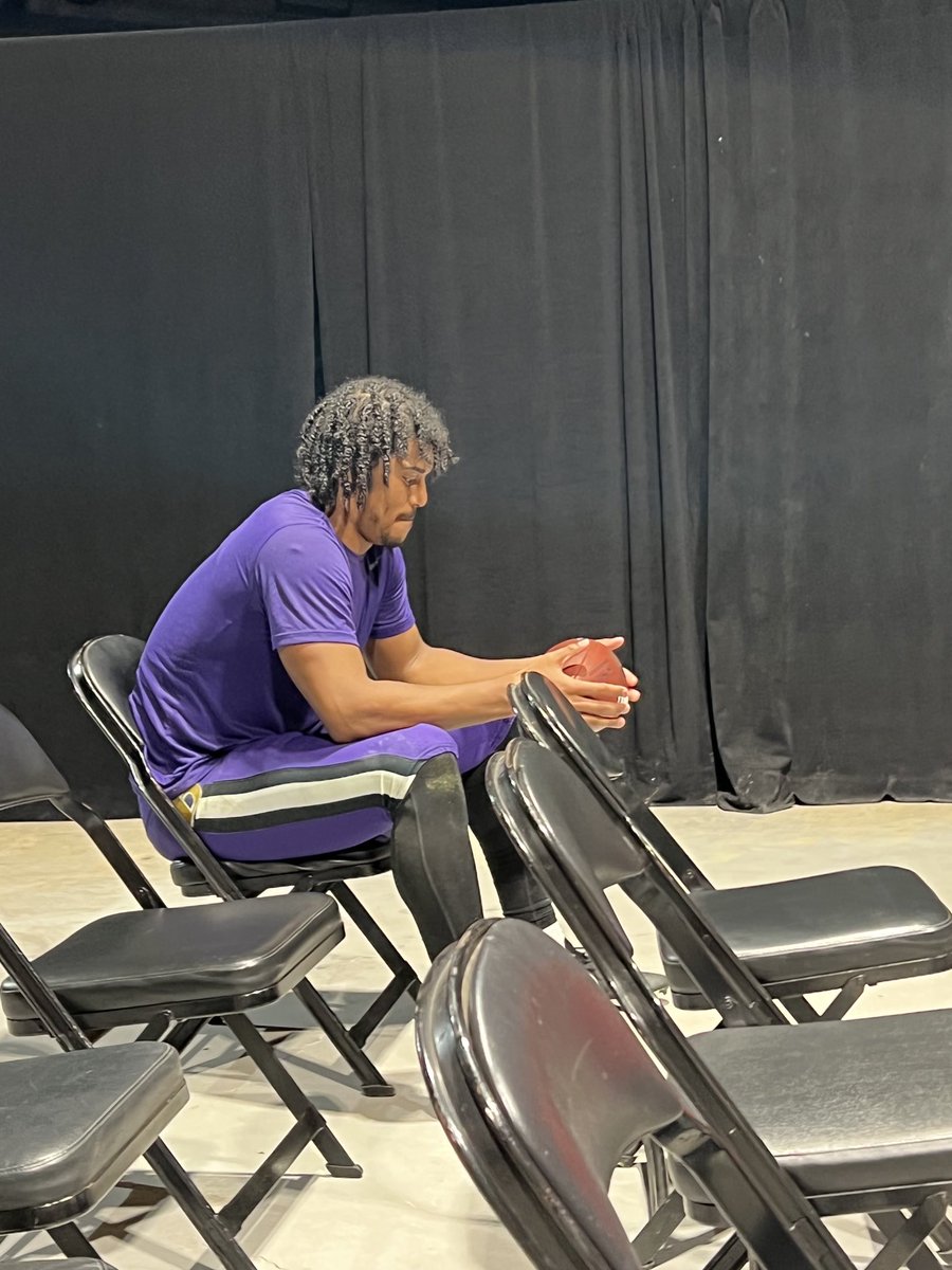 Isaiah Likely clutching the game ball as he awaits his turn beyond podium.