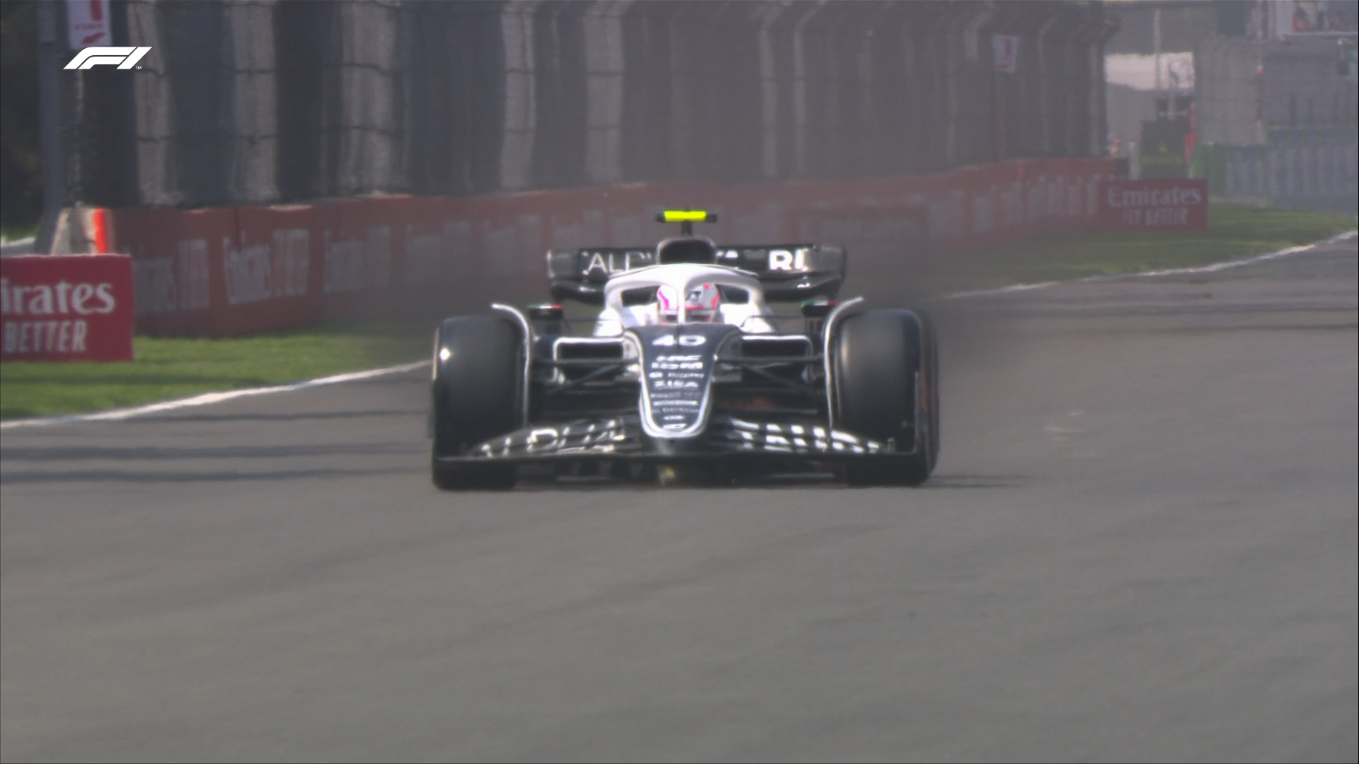 AlphaTauri reserve driver Liam Lawson brakes for Turn 1, but plumes of black brake dust can be seen emanating from both front wheels