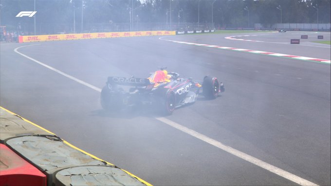 Max Verstappen's Red Bull can be seen facing the wrong way, off-track with white tyre smoke surrounding him. There is no damage to the car
