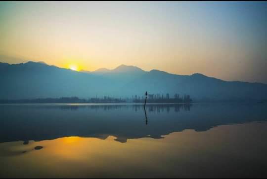 Water reflecting off the misty peaks of the Zabarwan mountains! @Kashmir_Weather