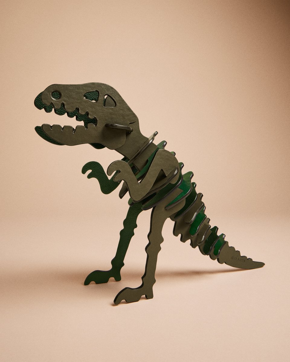 Coach's tweet photo. Wondering how our #CoachReLoved and Repair Workshop craftspeople turned preloved, deconstructed bags into a dino puzzle? We'll fill in the missing 🧩s. Shop now: https://t.co/6dmVw5VkDL. #CoachNY https://t.co/hjOfb0mZ1L