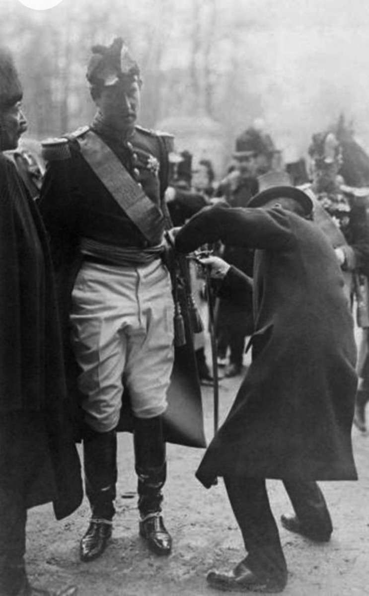 An aide is helping King Albert I of the Belgians with his sabre (1909)