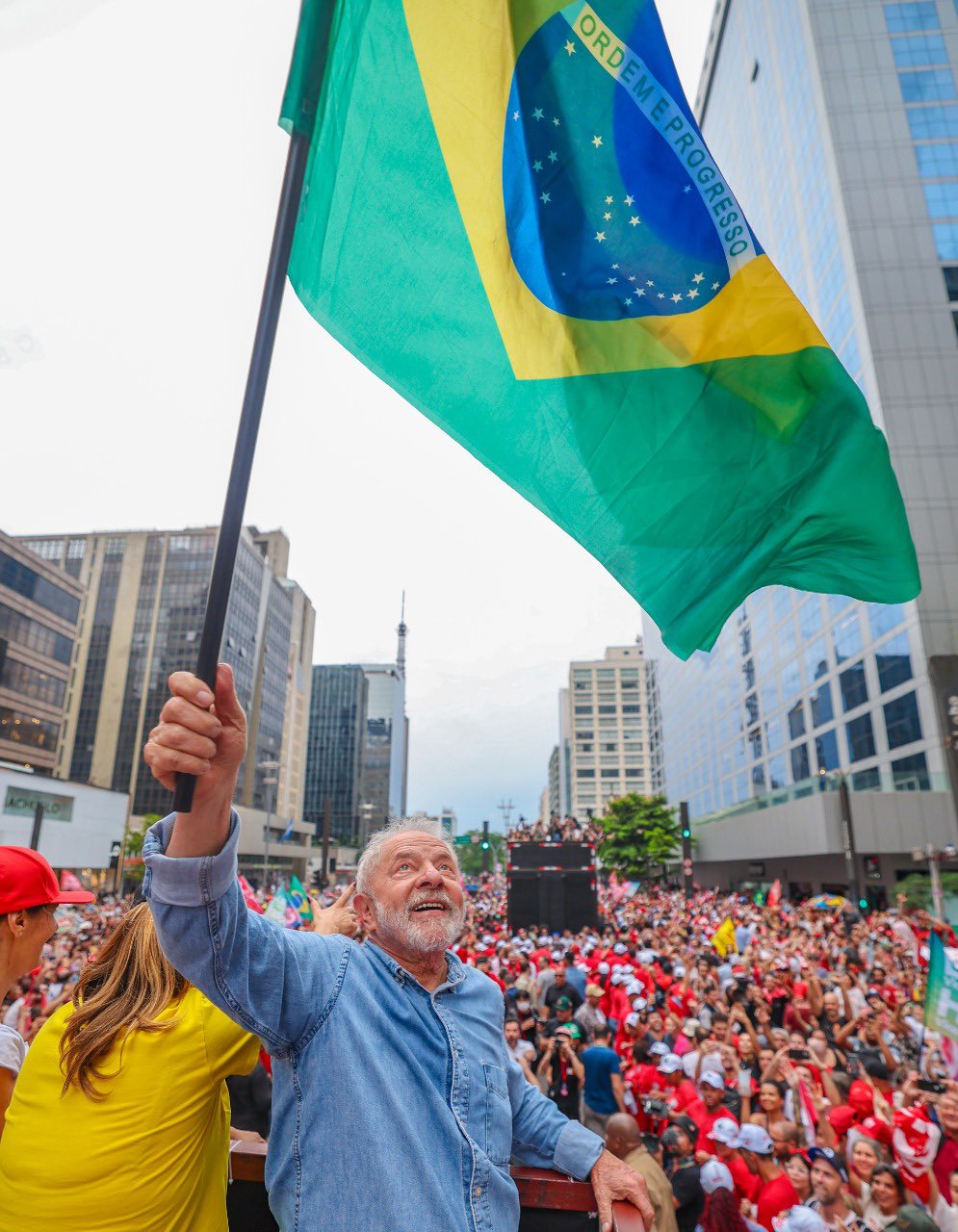 Lula sorri e levanta bandeira do Brasil