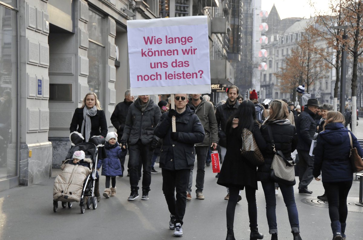 samim's tweet photo. "Together against the stupidity of prosperity" - Unauthorized protest and sign by @while1 - the Sign says "How much longer can we afford this?" https://t.co/Uz3lUyhTu1 https://t.co/FbUPPGeDZu