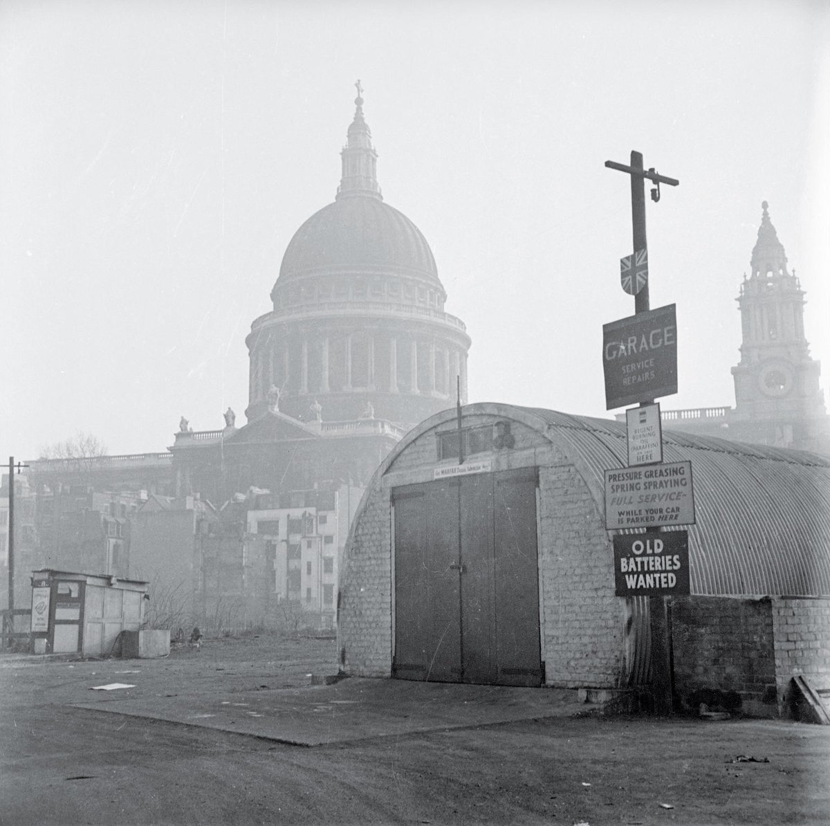 robnitm's tweet photo. A garage next to St Paul’s Cathedral, c.1950 - photo by Nigel Henderson https://t.co/NJfGWin8Im