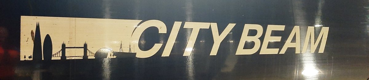 Jezzatrainman's tweet image. Two tiny, yet lovely, details on the City Beam logo that are easily missed because they are lower down, and you have to be relatively close to notice.  Firstly, the dog walker in the park, and then the cyclist heading towards city Hall.  #class707 #London