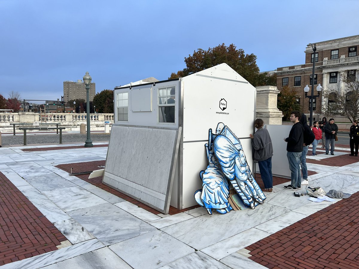steveahlquist's tweet photo. Advocates build a pallet shelter on the Rhode Island State House plaza, near Smith Street. These shelters could help alleviate the terrors of homelessness in Rhode Island this winter. @UpriseRI @rihomeless @houseofhopecdc @GovDanMcKee https://t.co/5Zz4uPD9Hk