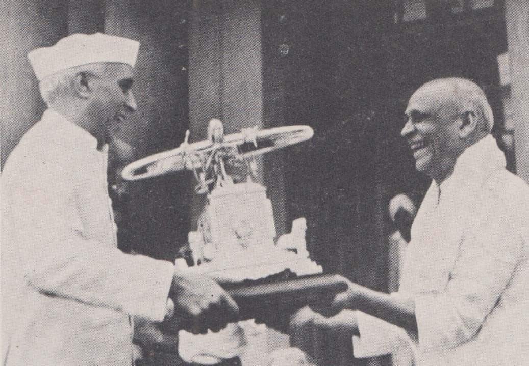 Jawaharlal Nehru presenting a memento modelled after an aeroplane to Sardar Vallabhbhai Patel who had a miraculous escape when his plane forcelanded near Jaipur , April 1949.
