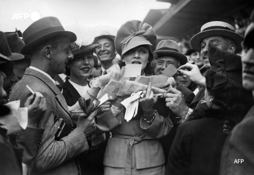AFPcom's tweet photo. 🗃 #AFPArchives - L'actrice Marlene #Dietrich signes des autographes à l'hippodrome de Longchamp, près de Paris (1939).
📸 Photo #AFP
👀 Un tirage unique de cette photo est disponible à la vente aujourd'hui à la #ElliaArtGallery et sur le site @Drouot - #AFPAuction https://t.co/wvnEXupLDw