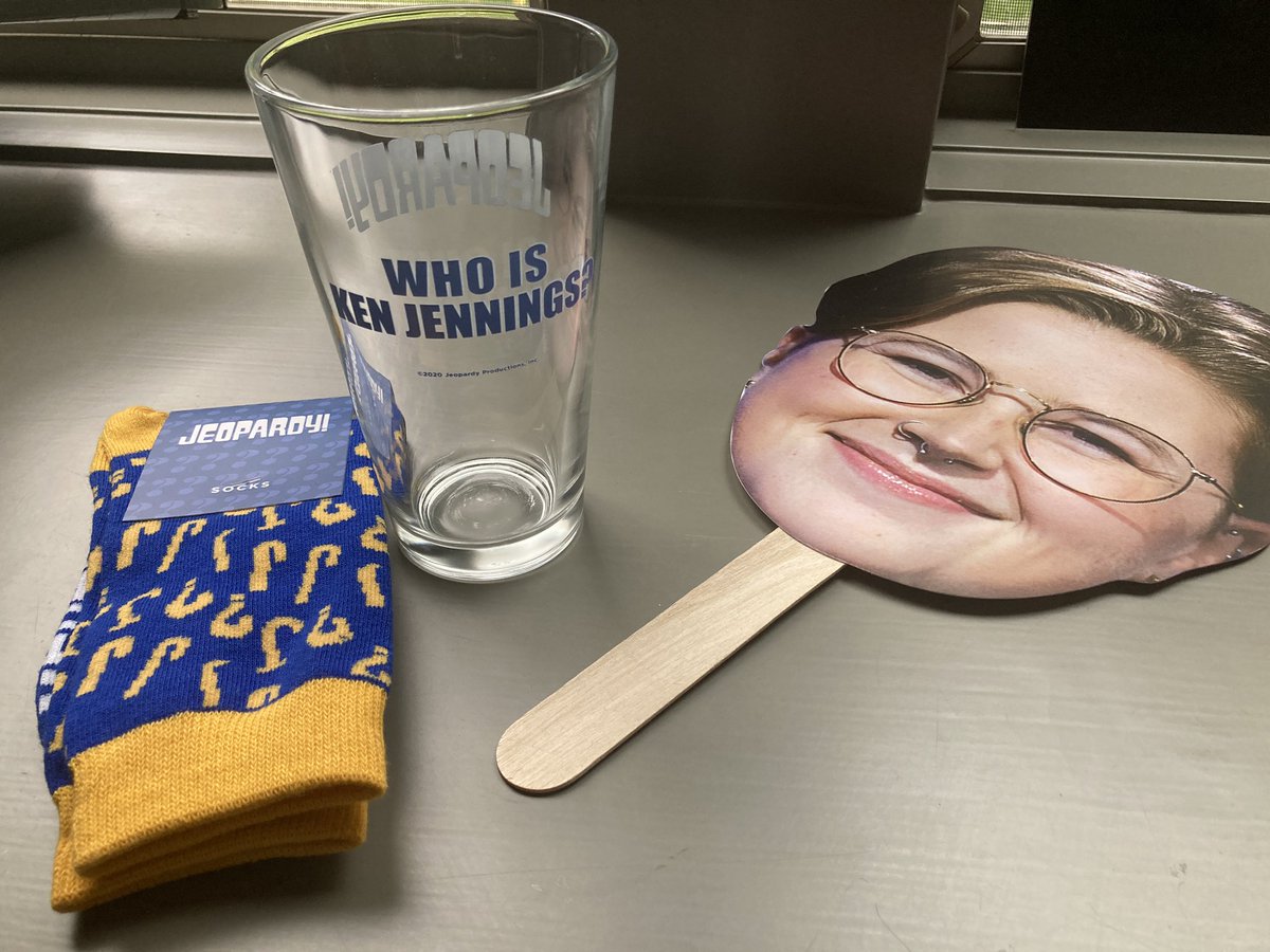 A Tournament of Champions promo kit just showed up in the mail. My swag includes: @Jeopardy! socks, Mattea Roach cosplay, drinking glass seemingly designed to produce existential angst.