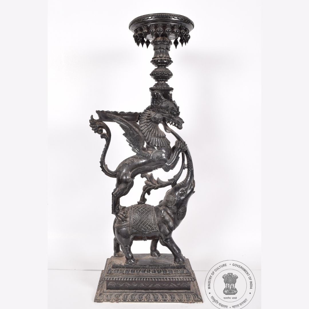 sjmhyd's tweet photo. This temple lamp is carved out of wood and dates back to the 20th century. Its stand is carved to represent a Yali on the back of an elephant. The actual lamp is place above the Yali figure with downward ornamental knobs.
#SalarJungMuseum #TempleLamp https://t.co/SsUlQ3IkyF