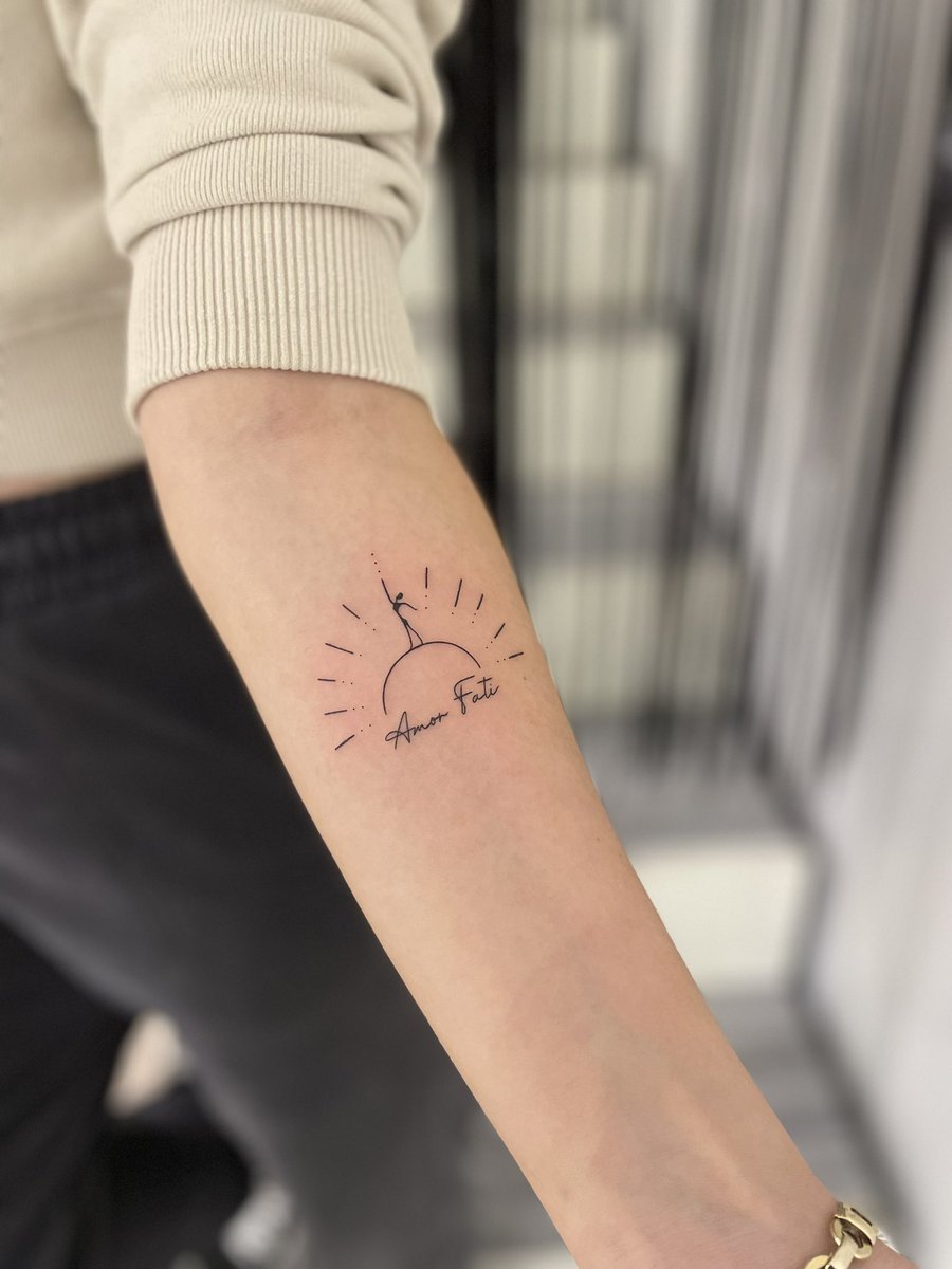 Amor fati” tattoo on the right forearm.