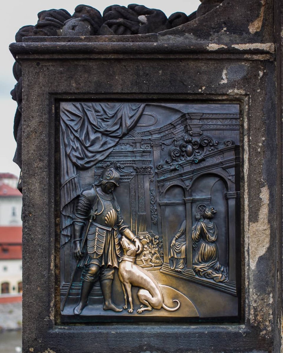 Carving of a dog on St John of Nepomuk's statue glowing gold from people petting it for hundreds of years. Photo by Frank Boston