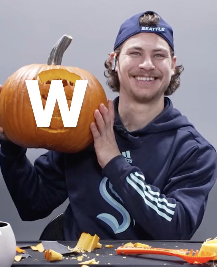 Gourde smiling and holding up a pumpkin with a w photoshopped on it