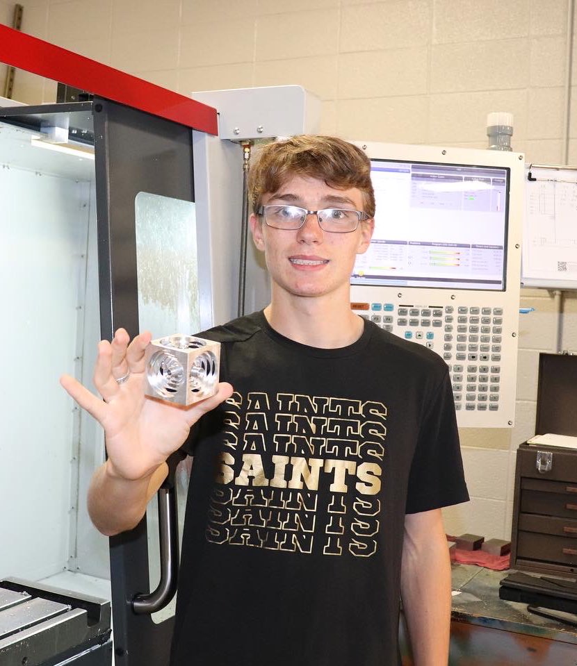 dmtcsc's tweet image. Grayson Grazel, a Broome High School freshman, is shown with his completed Turner’s Cube project.  He designed and programmed the part in Fusion 360, then set up the CNC Machining center to machine the finished product.  Great job, Grayson!  #DMTCPrepares #MachineToolTechnology